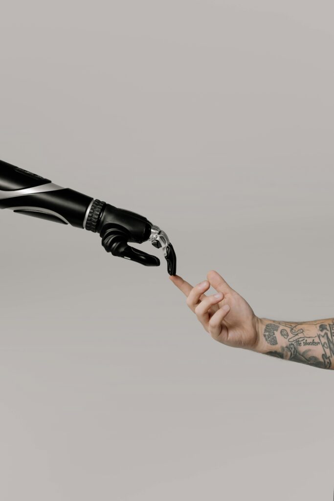 pexels-photo-6153345-6153345 Close-up of a prosthetic arm and a human hand reaching towards each other in harmony.